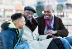 A teenager sitting with two elderly men