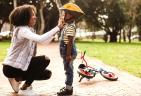 A mom helping her young son put his bike helmet on