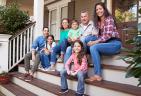 A large family sitting on a front porch