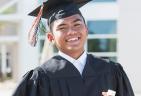 A smiling teenager wearing a graduation cap and gown
